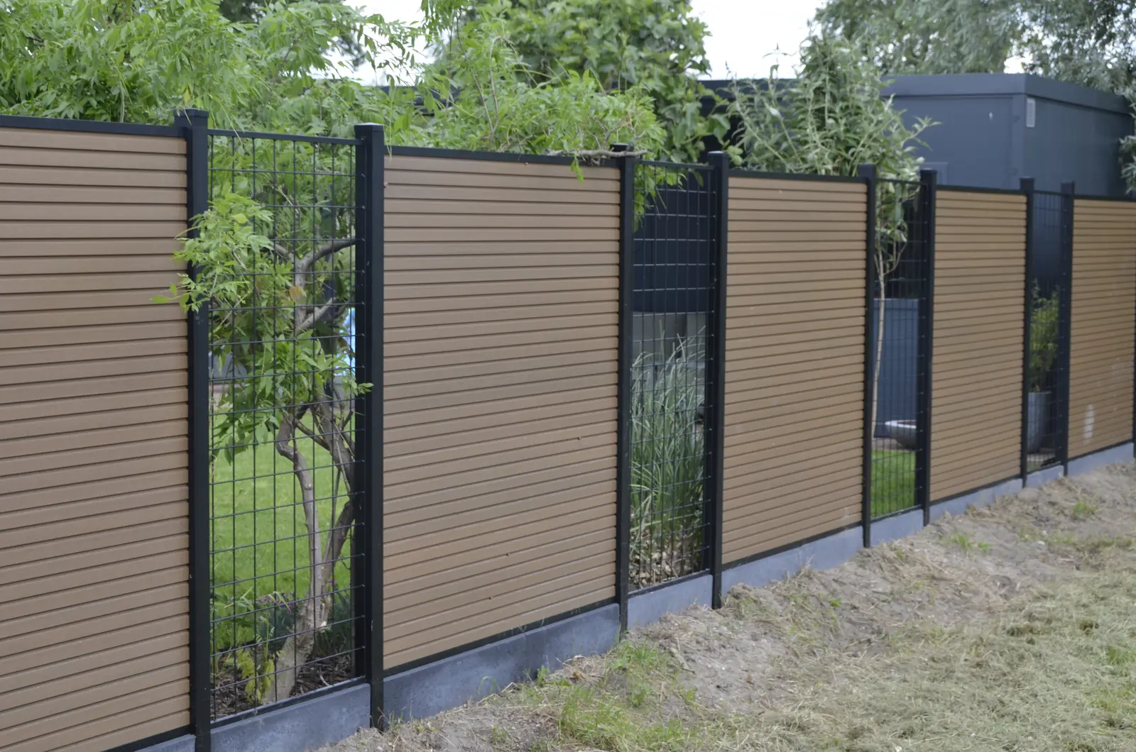 Hoek van de schutting met de aluminium paal in het zicht