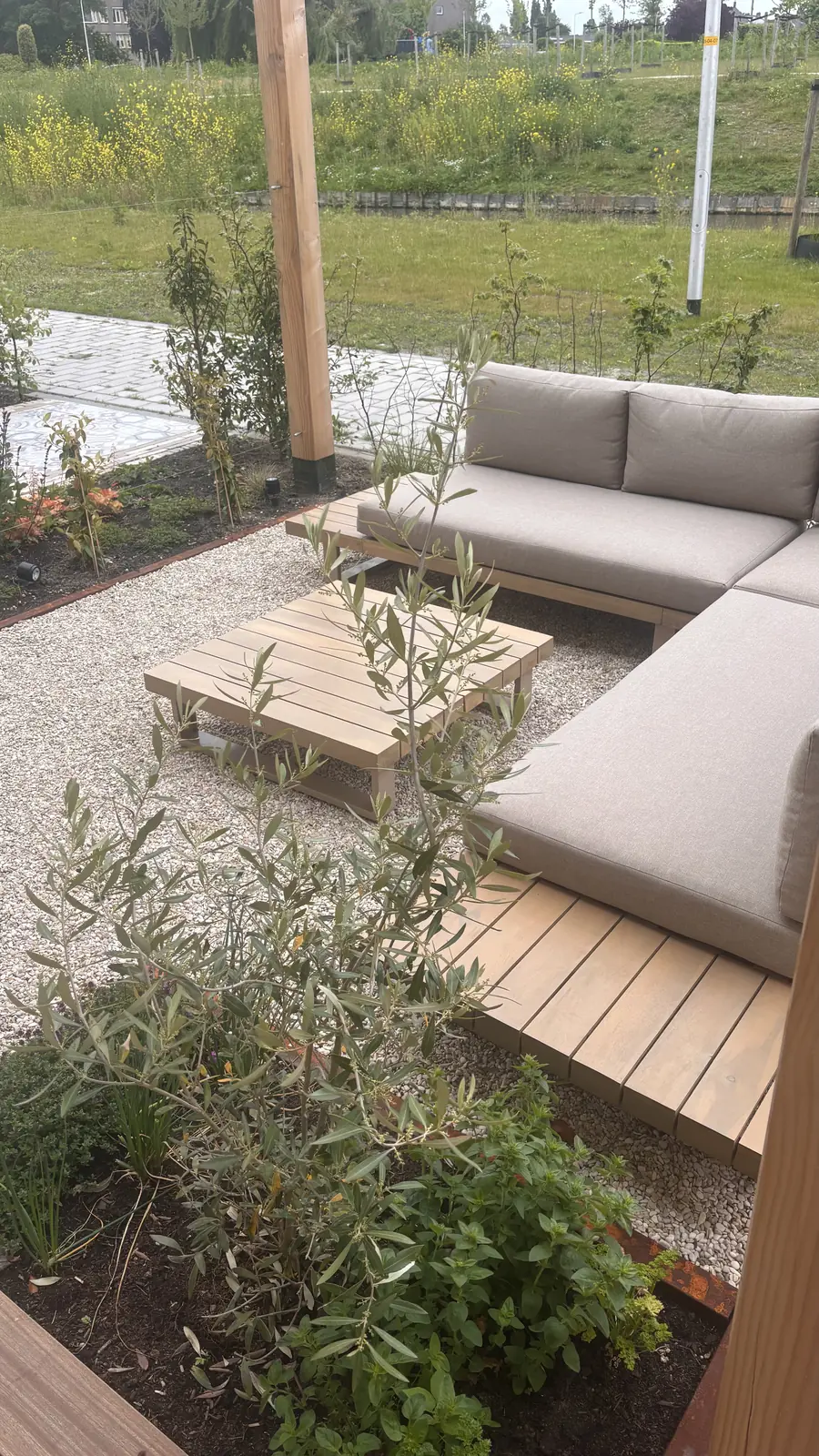 Loungeset op de hardhouten vlonder tussen de beplanting