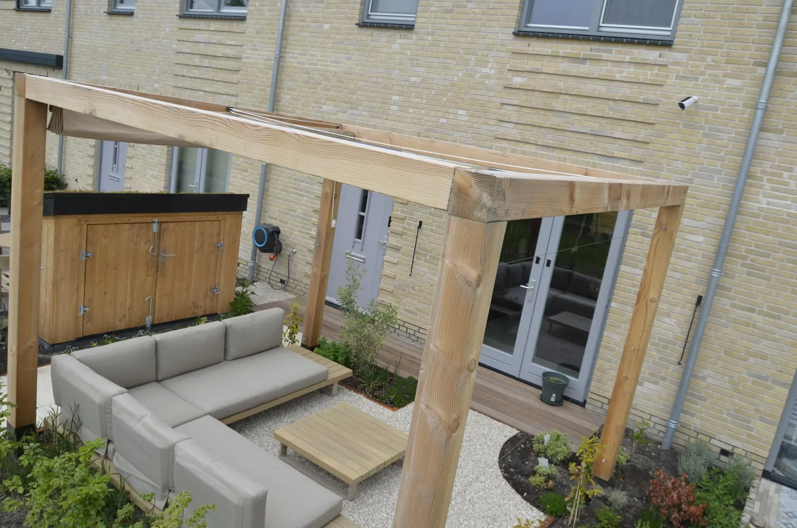 Pergola en vlonder langs de gevel