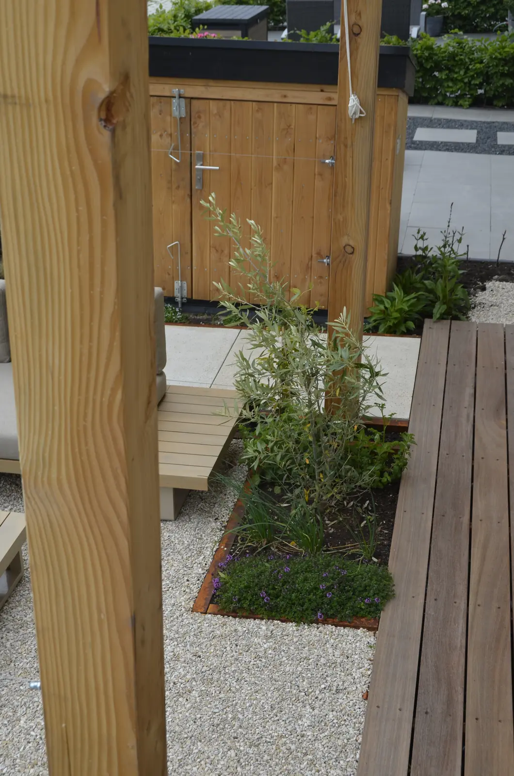 Houten staander van de pergola met de border ernaast