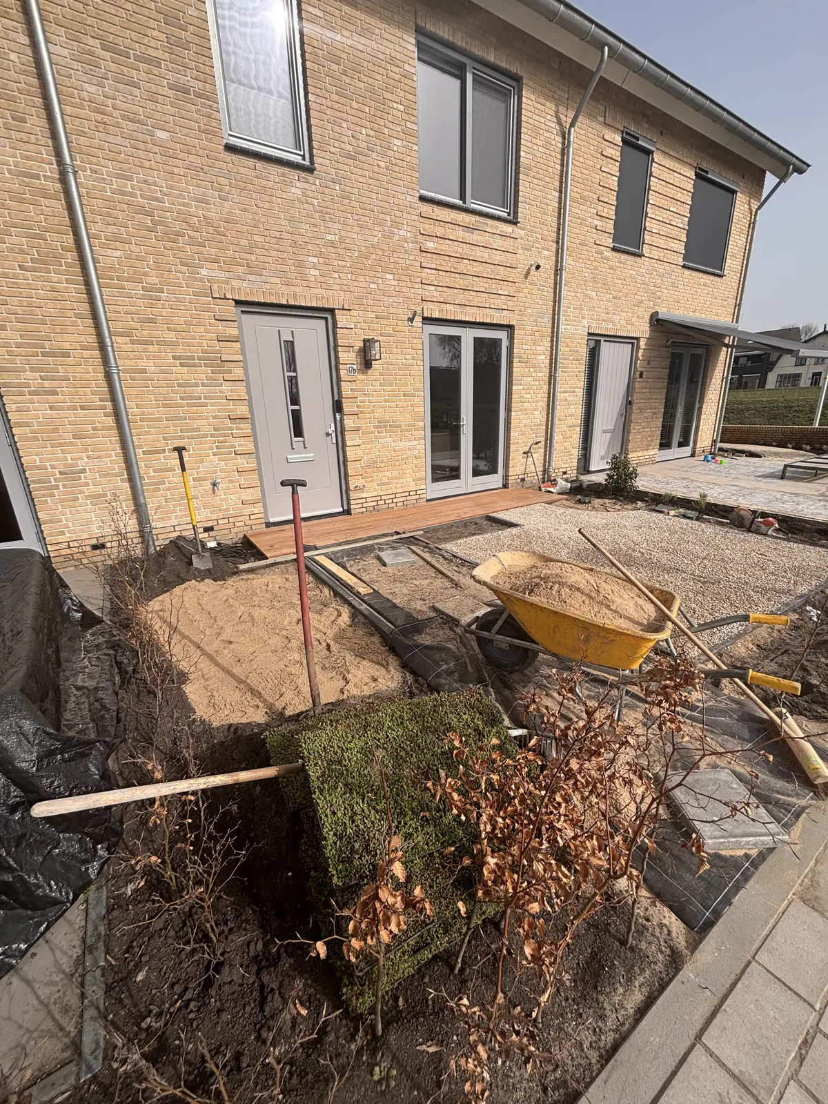 De tuin bij aanvang: uitgegraven en met een kruiwagen