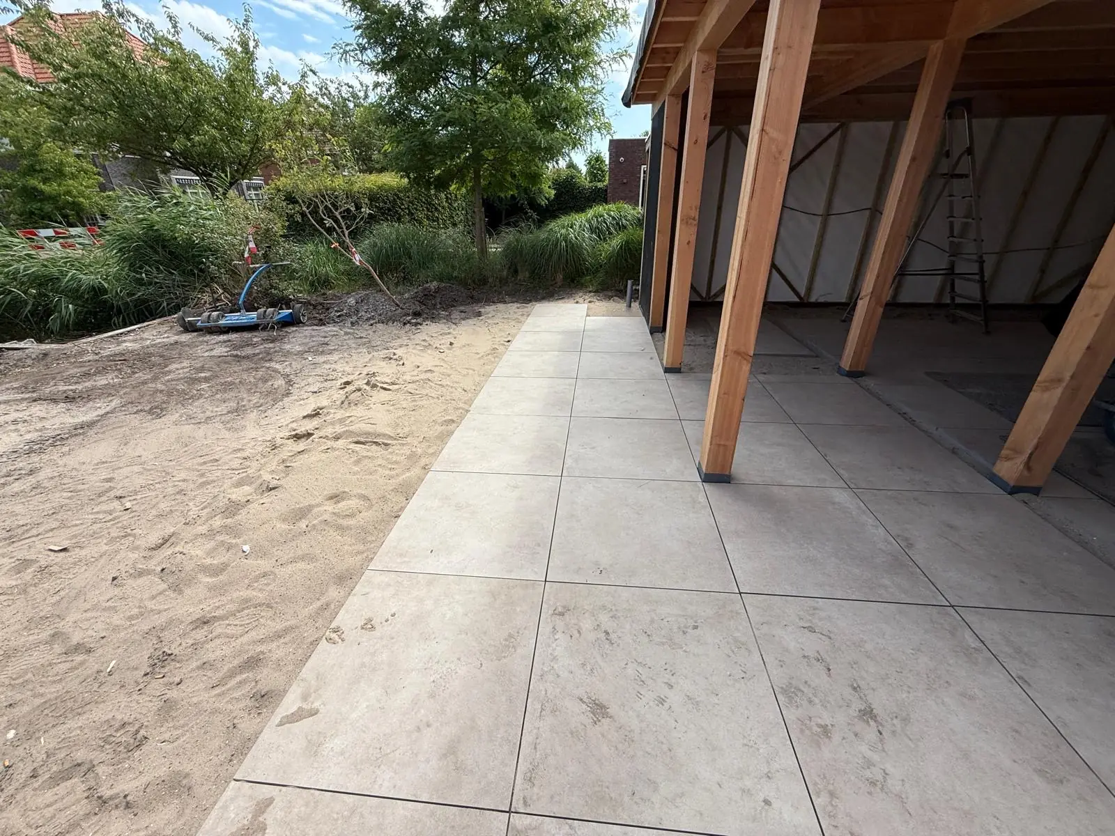 Het terraspad door het zand naar de overkapping