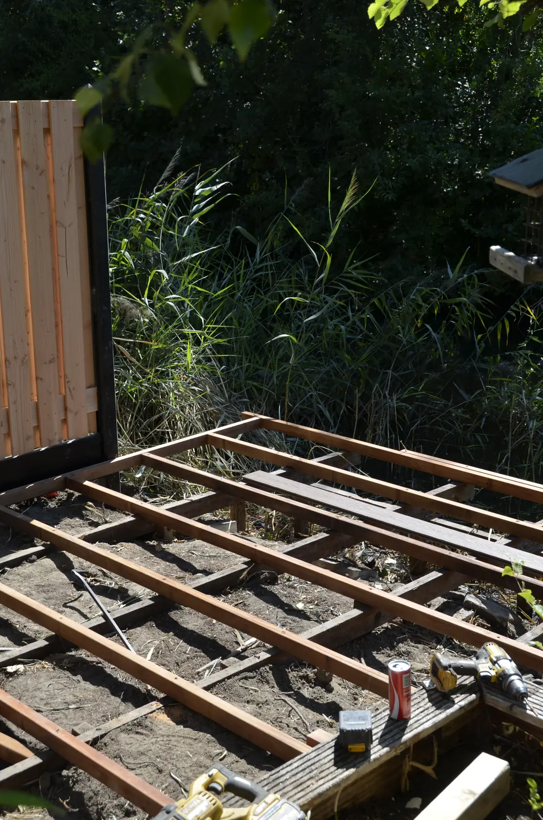 Hardhouten onderbouw van de vlonder naast de nieuwe schutting