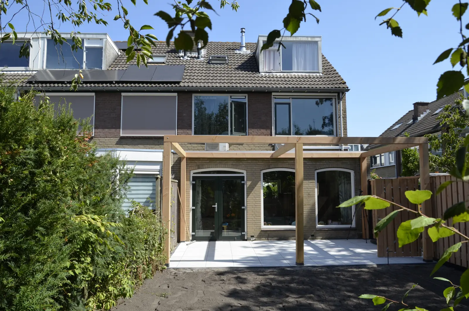 Houten pergola boven het nieuwe terras aan de achtergevel