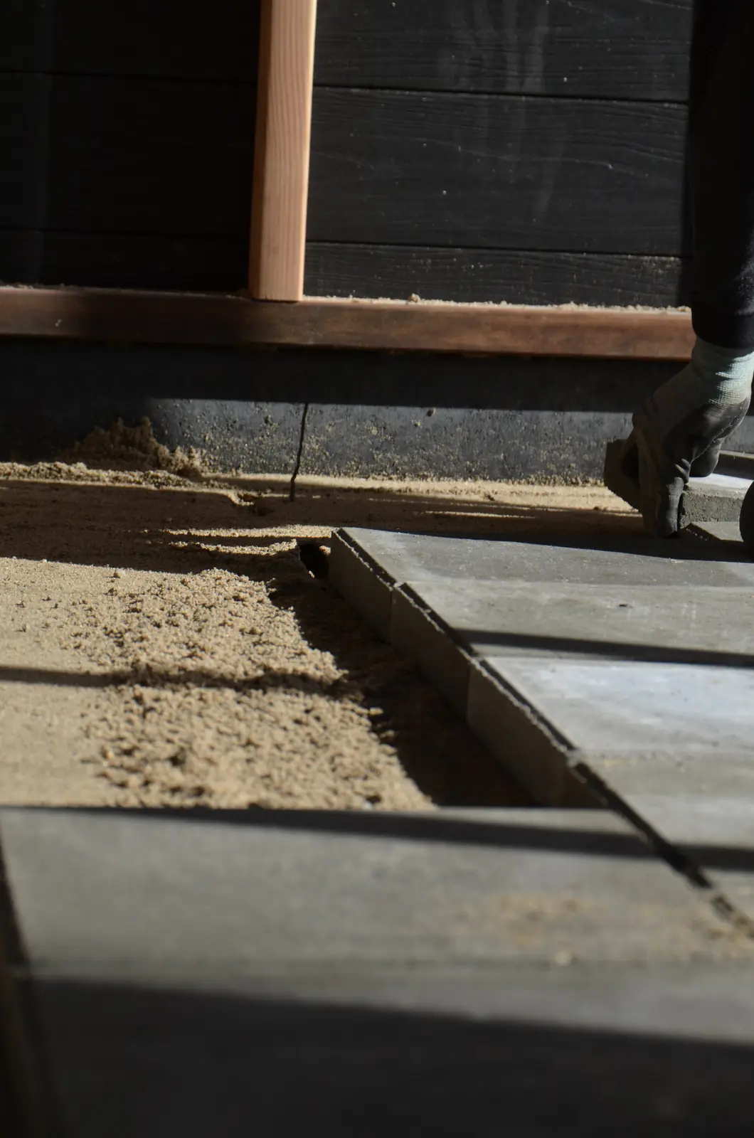 Tegels sluiten aan op de onderrand van de tuinhuiswand