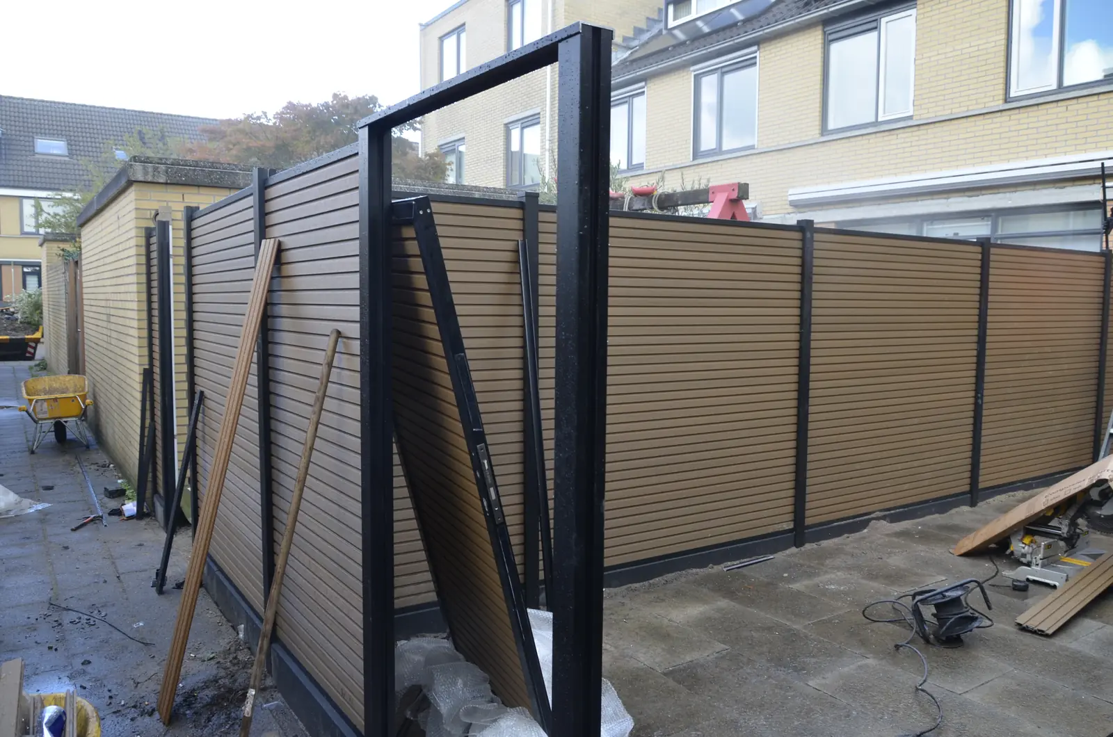 Composiet schutting in aanbouw, met het aluminium frame van de poort