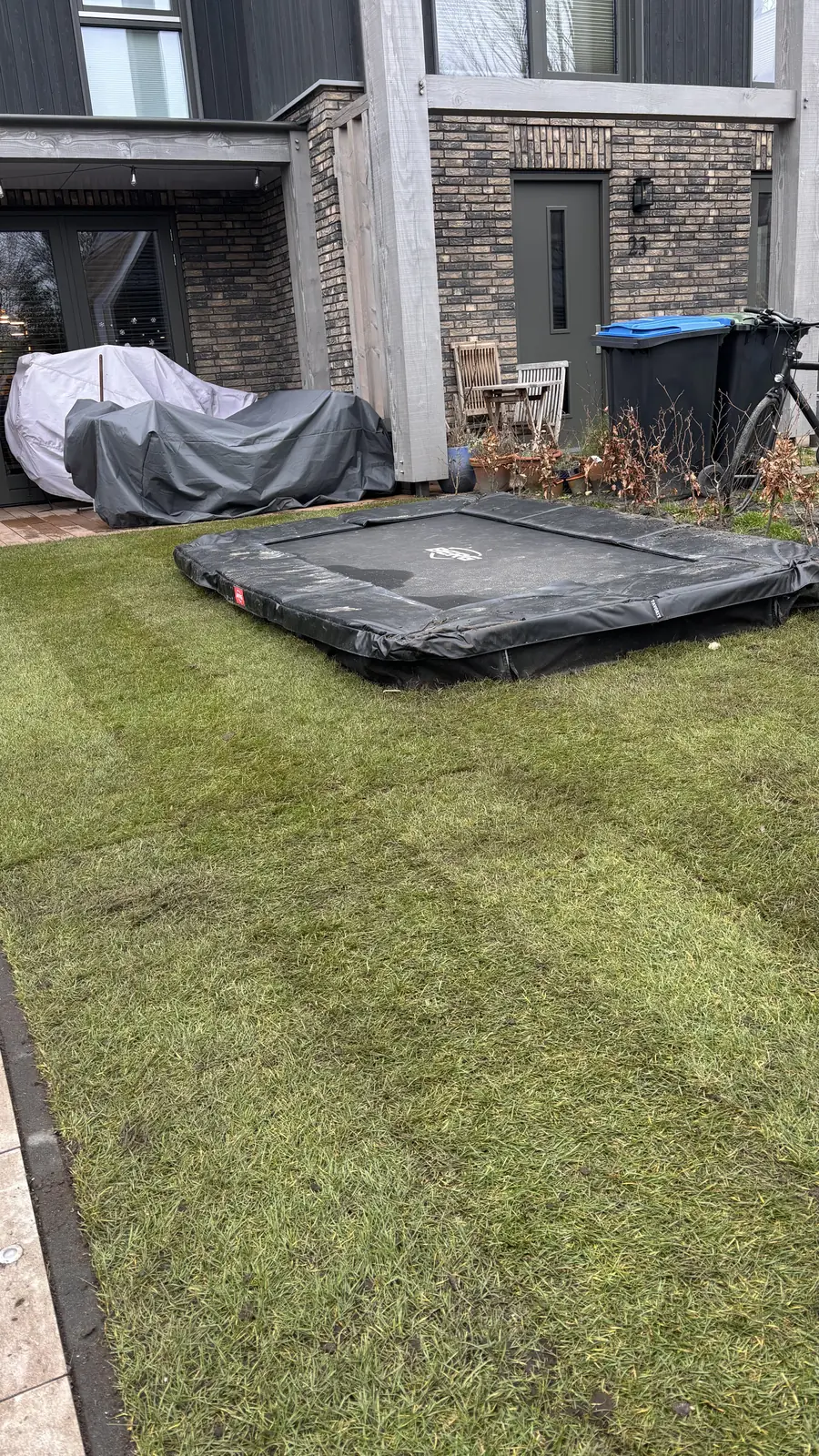 De hele tuin: overkapping, klinkers, gazon en verhoogde plantenbak