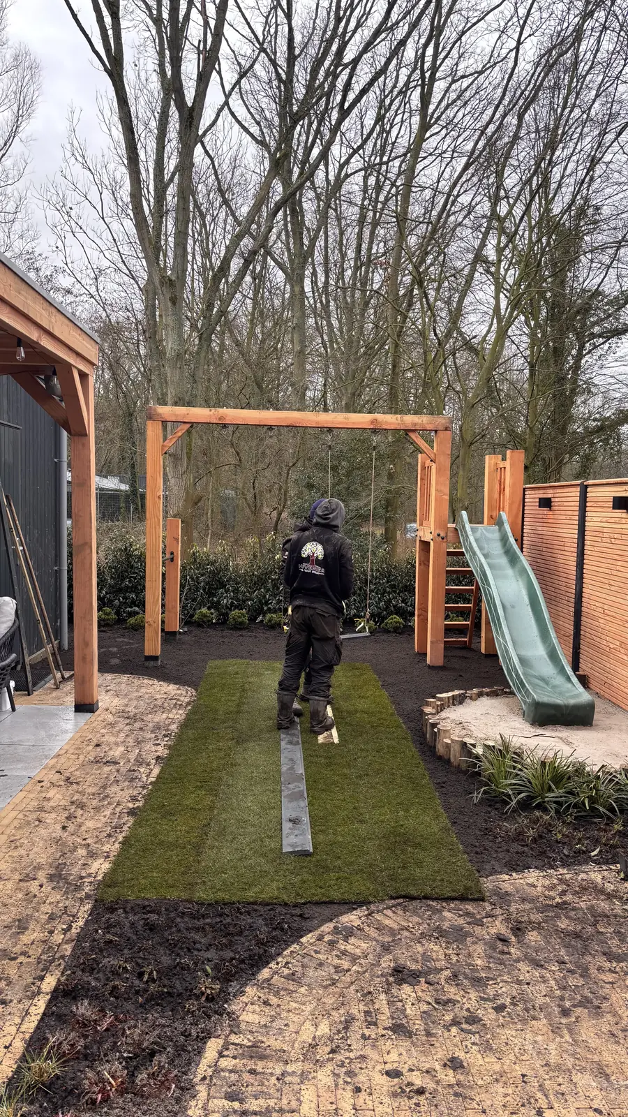 Klinkerpad met de glijbaan en het gras