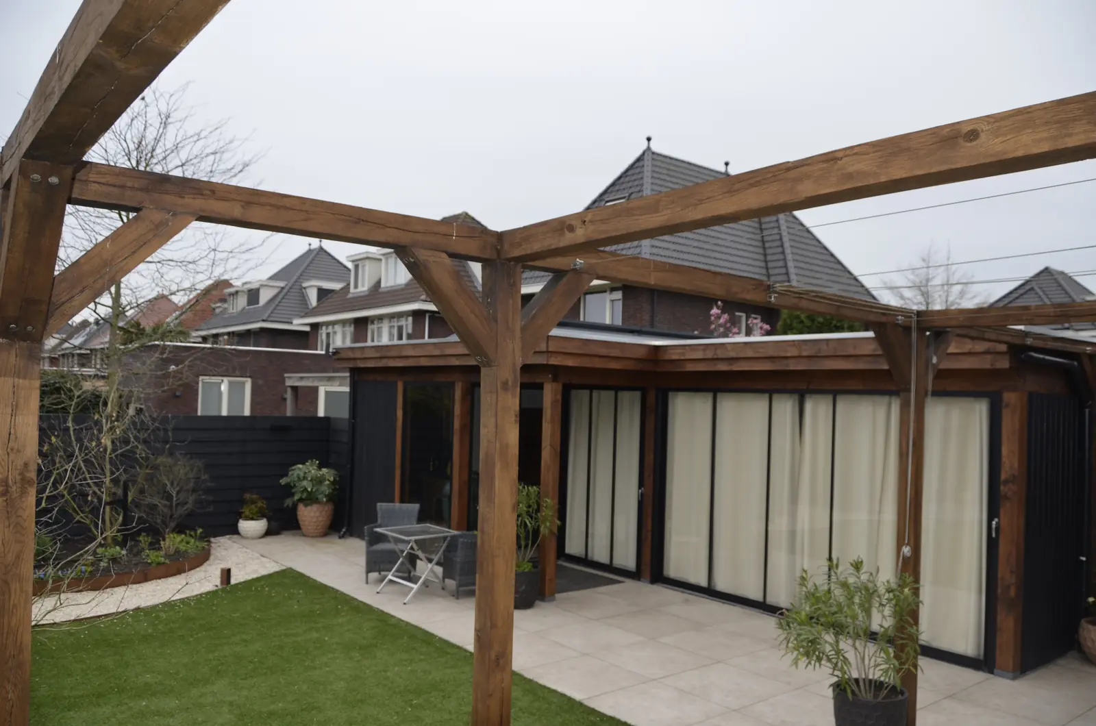 De overkapping met het terras en het gazon