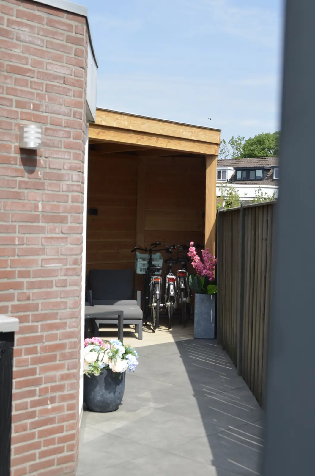 Afgeronde bestrating met de schutting en de veranda erachter