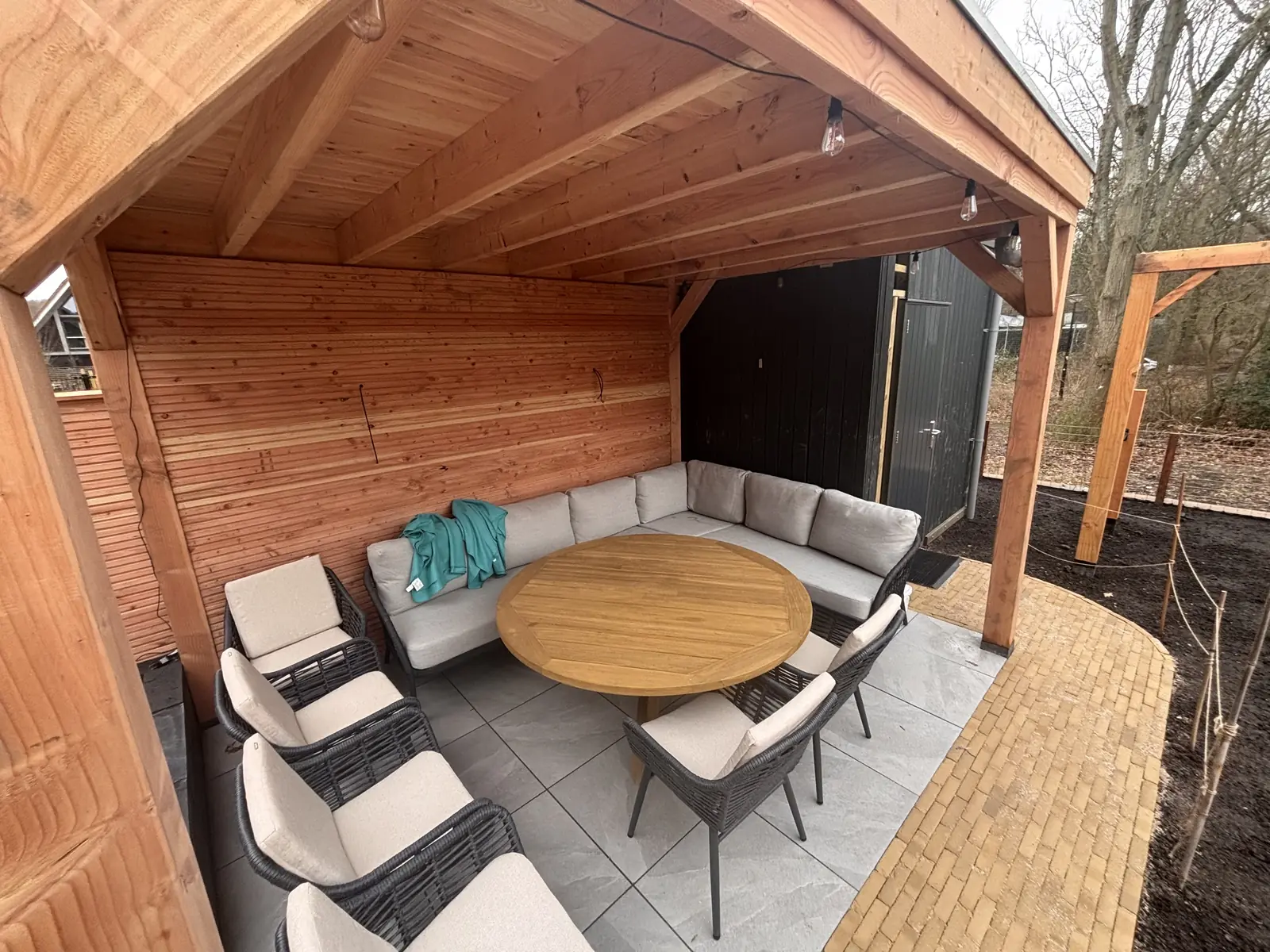 Zithoek onder de overkapping, met de tuin ervoor