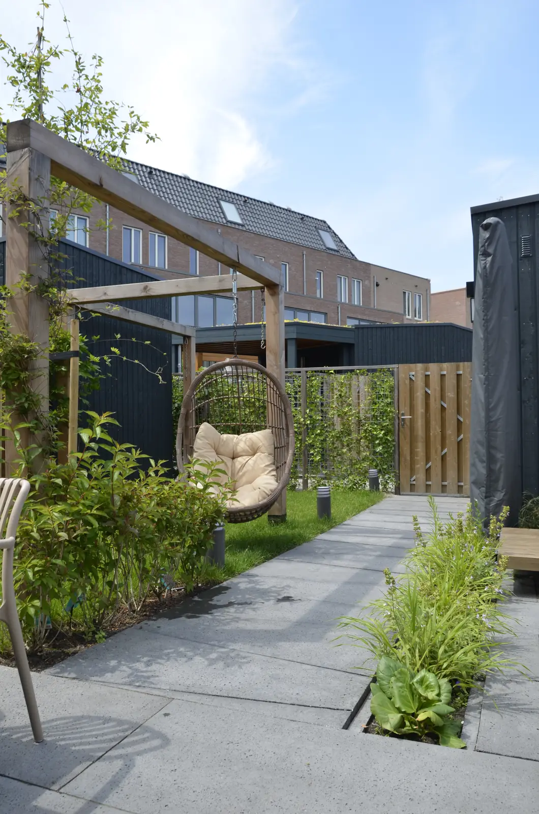 De tuin in het geheel: terras, gazon en pergola