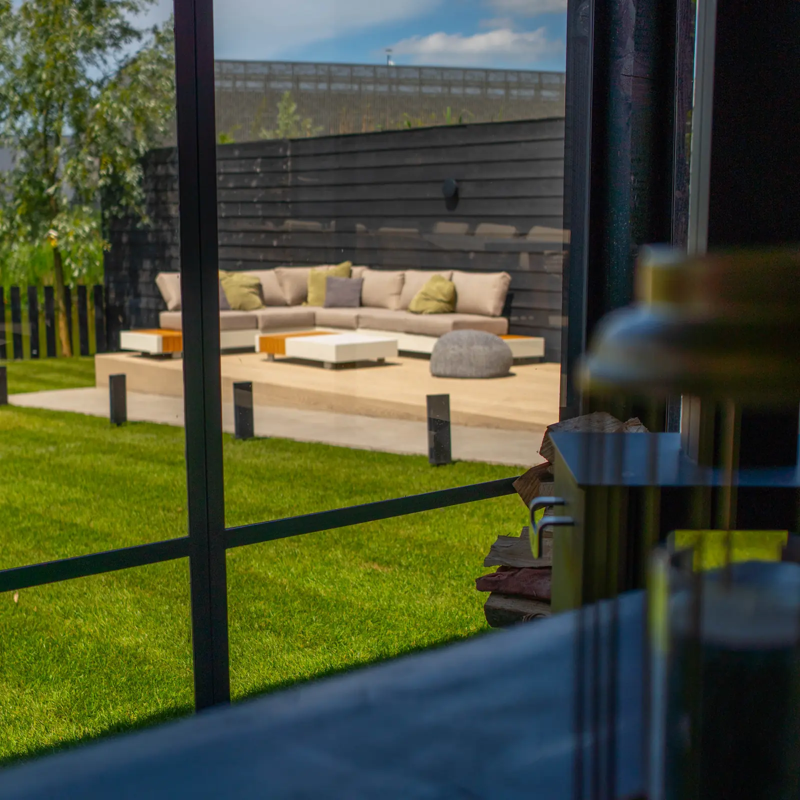 De loungehoek gezien door het glas van de veranda