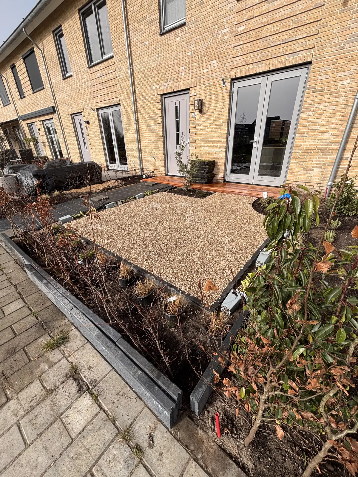 Zandbed langs de gevel voor het grind