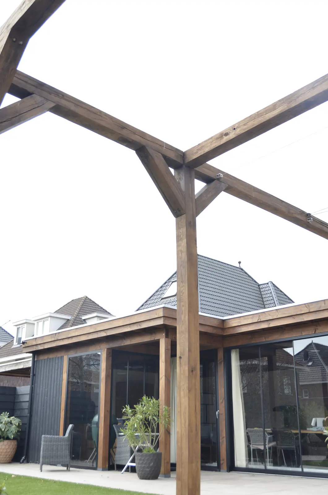 Zandvlakte met stapels tegels en een minigraafmachine achter in de tuin