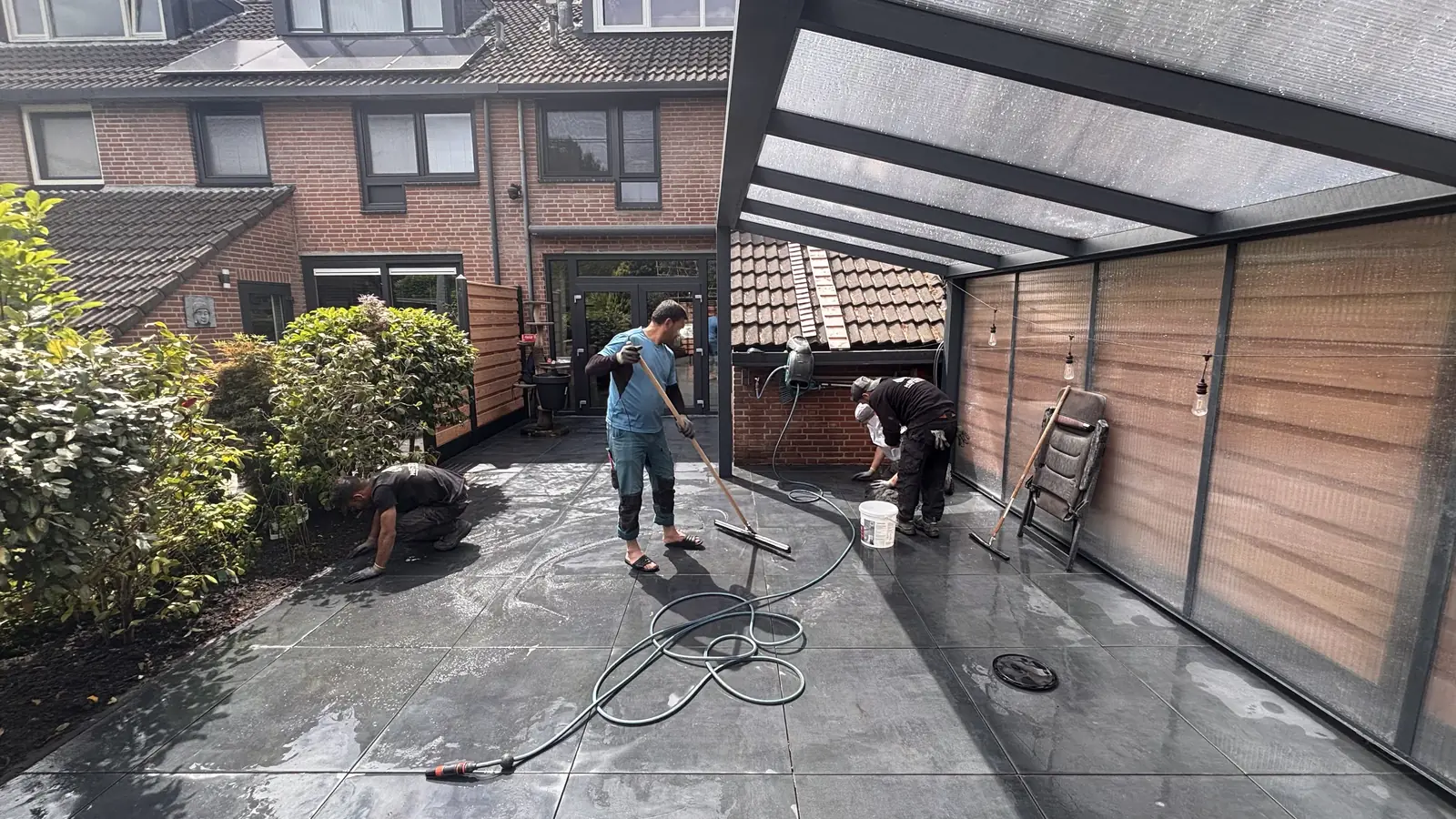 Twee hoveniers aan weerszijden van het terras