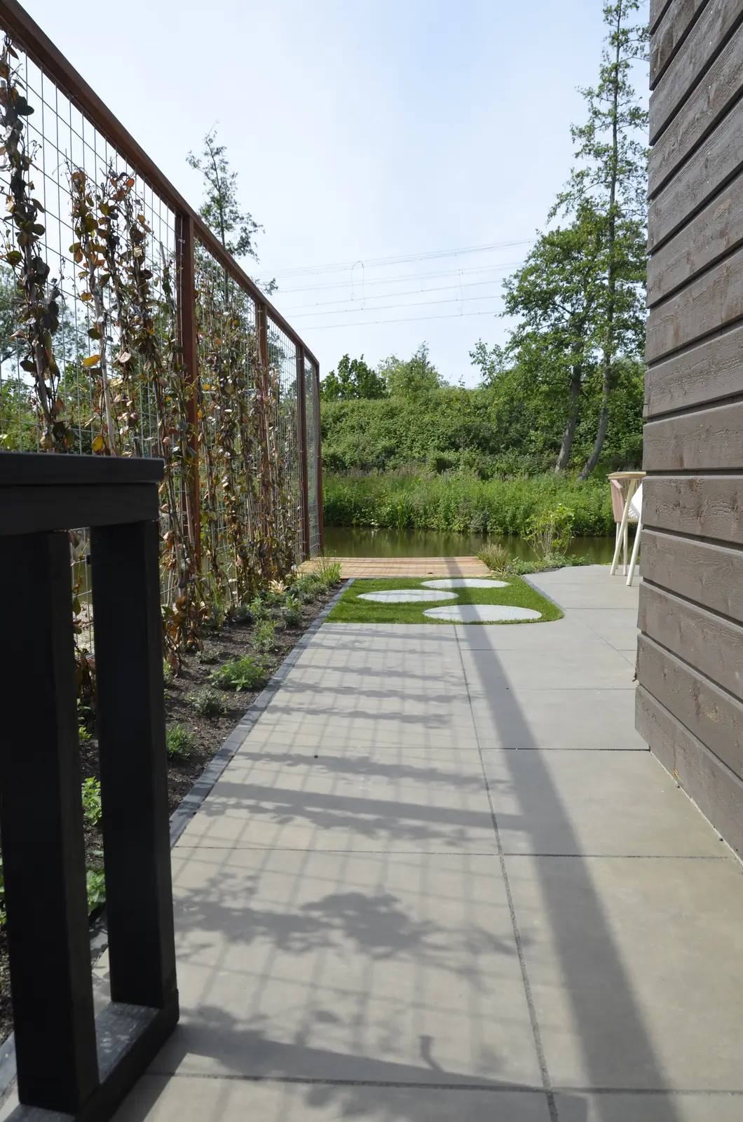 De woning aan het water voor de aanleg, kale grond tot aan de oever