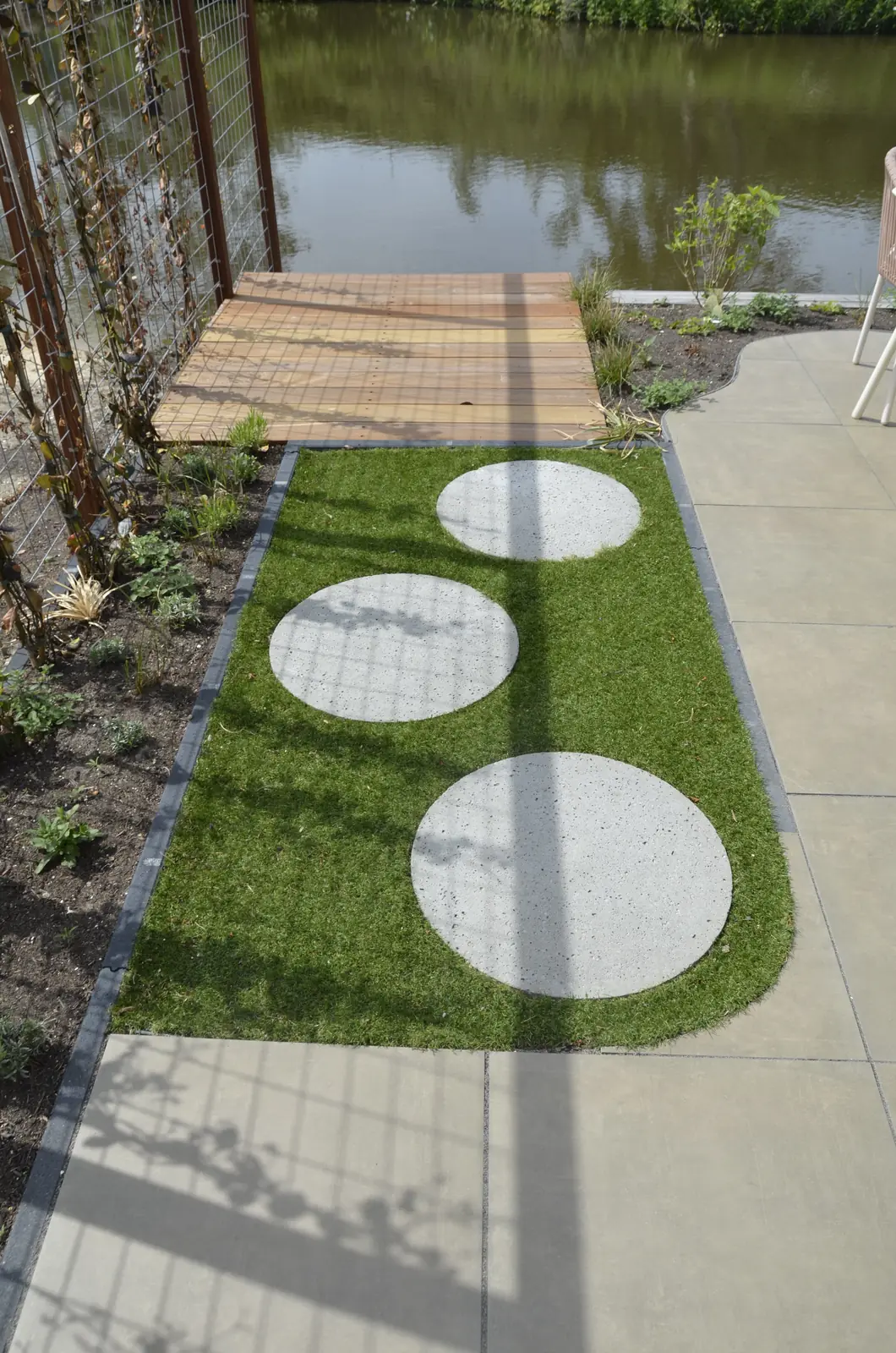 Smalle zijtuin met alleen zand langs de gevel