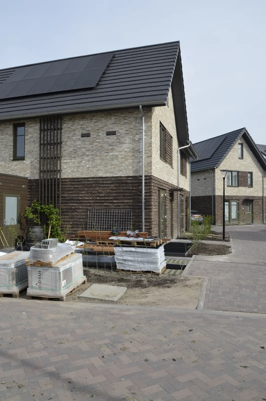 Nieuwbouwwoningen met materiaal op de stoep