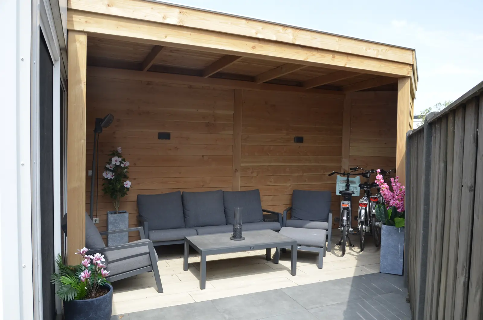 Detail van de schutting: houten scherm tussen betonpaal en onderplaat
