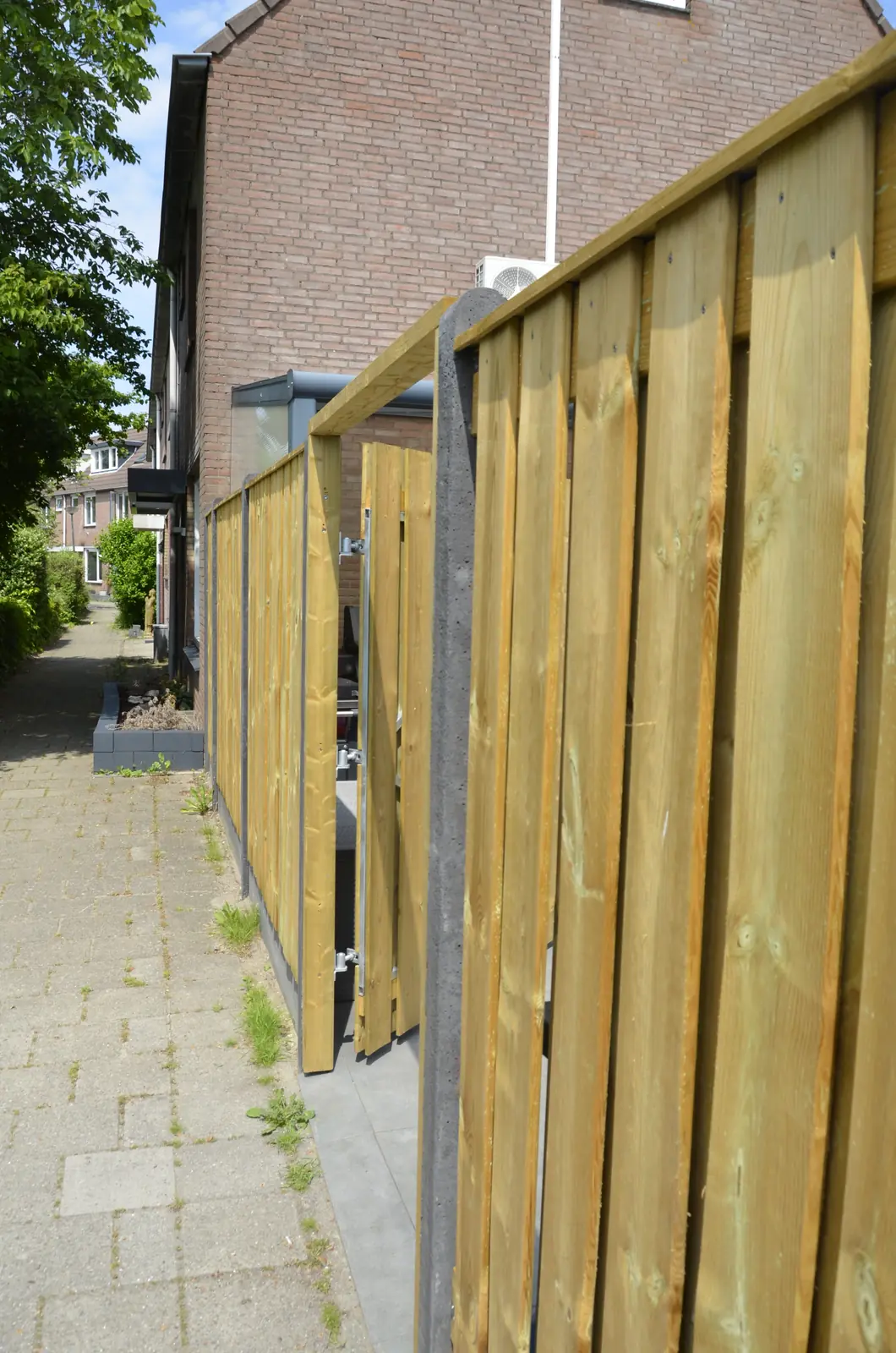 Hovenier legt een tegel op het zandbed langs de gevel