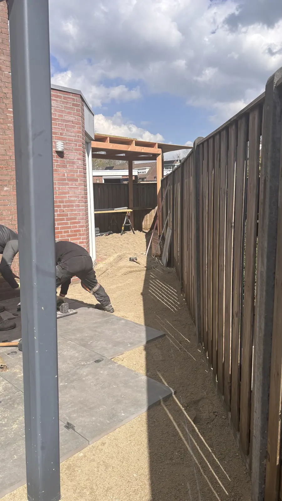 Hovenier aan het werk langs de schutting