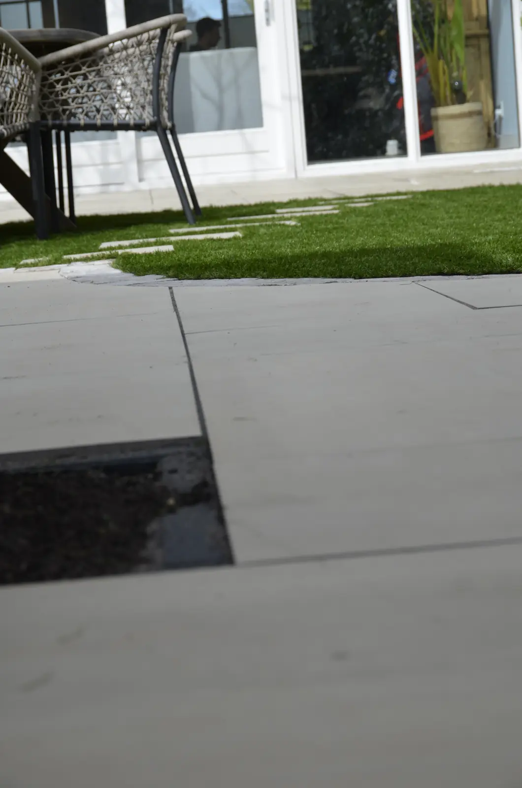 Terras en gazon met de klimopwand erachter