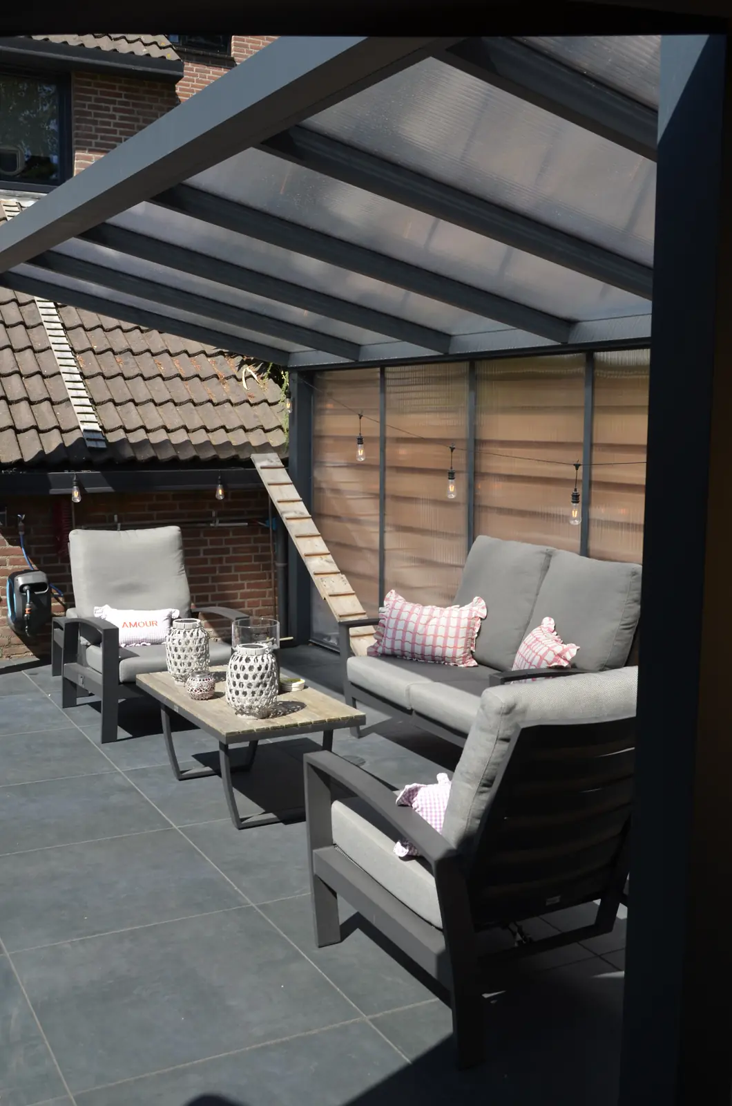 Terras met houten schutting, parasol en plantenbakken langs de rand
