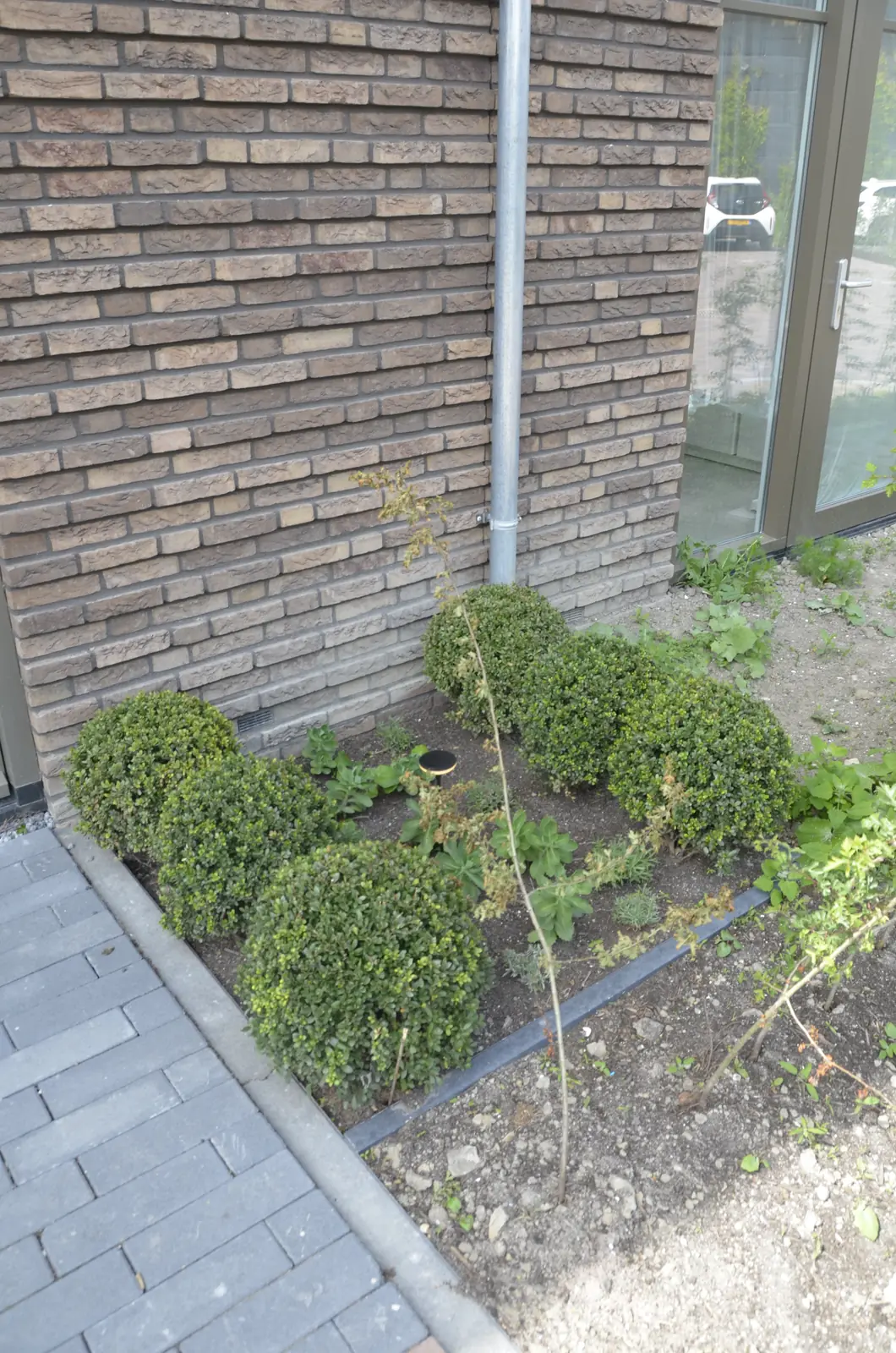 Berging met containerplek achter een houten wand, aan het water