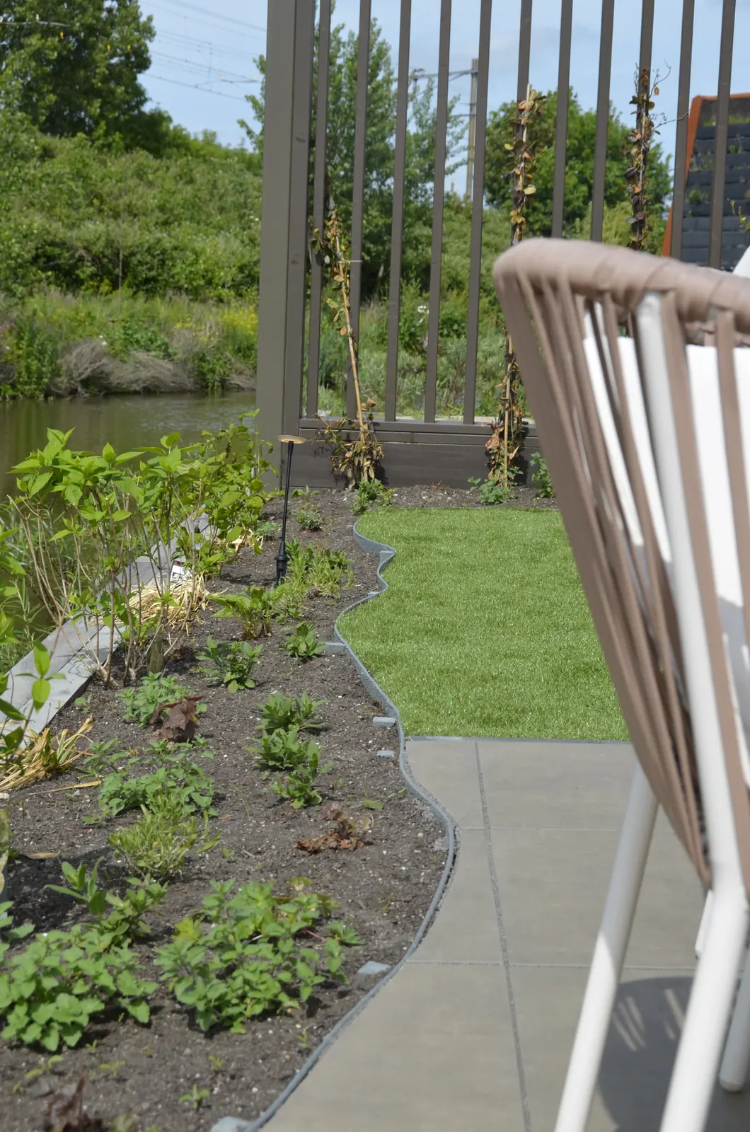 Border met beplanting langs het hekwerk aan het water