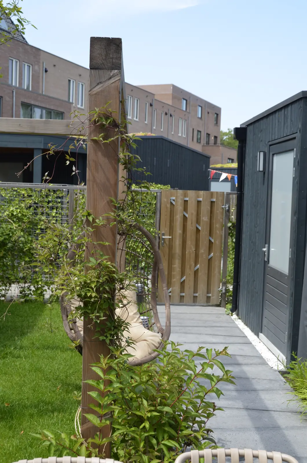 Pergola met hangstoel, gezien vanaf de woning