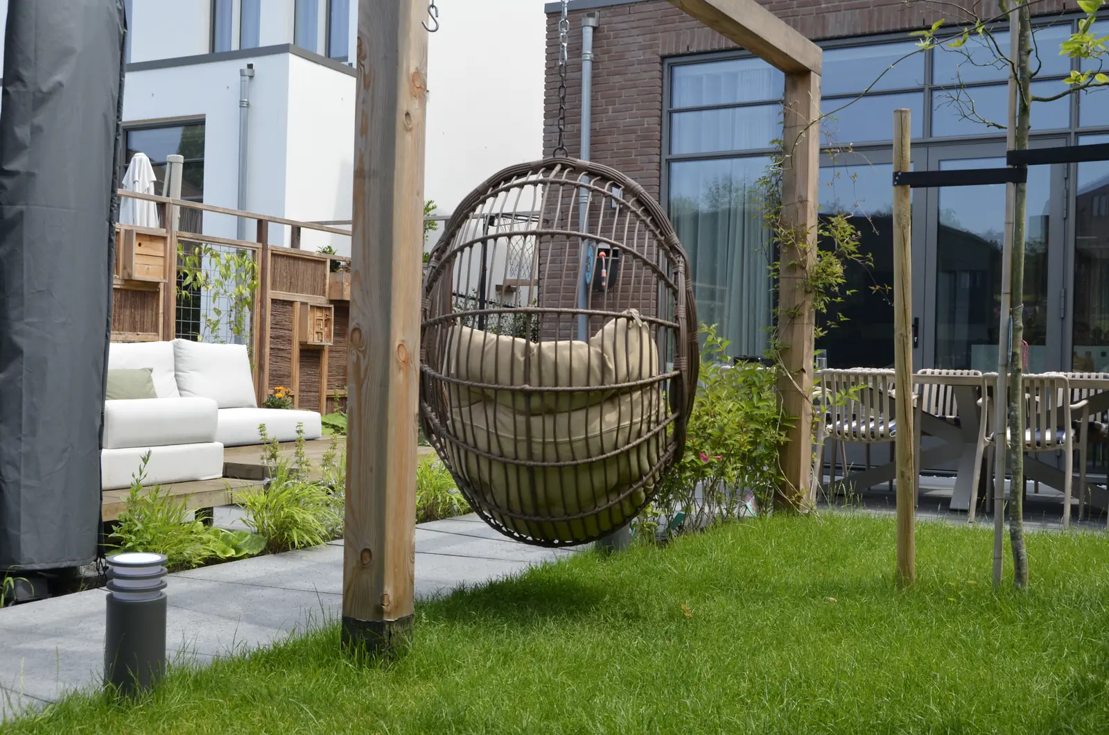 Terras met eettafel en de hangstoel op de achtergrond