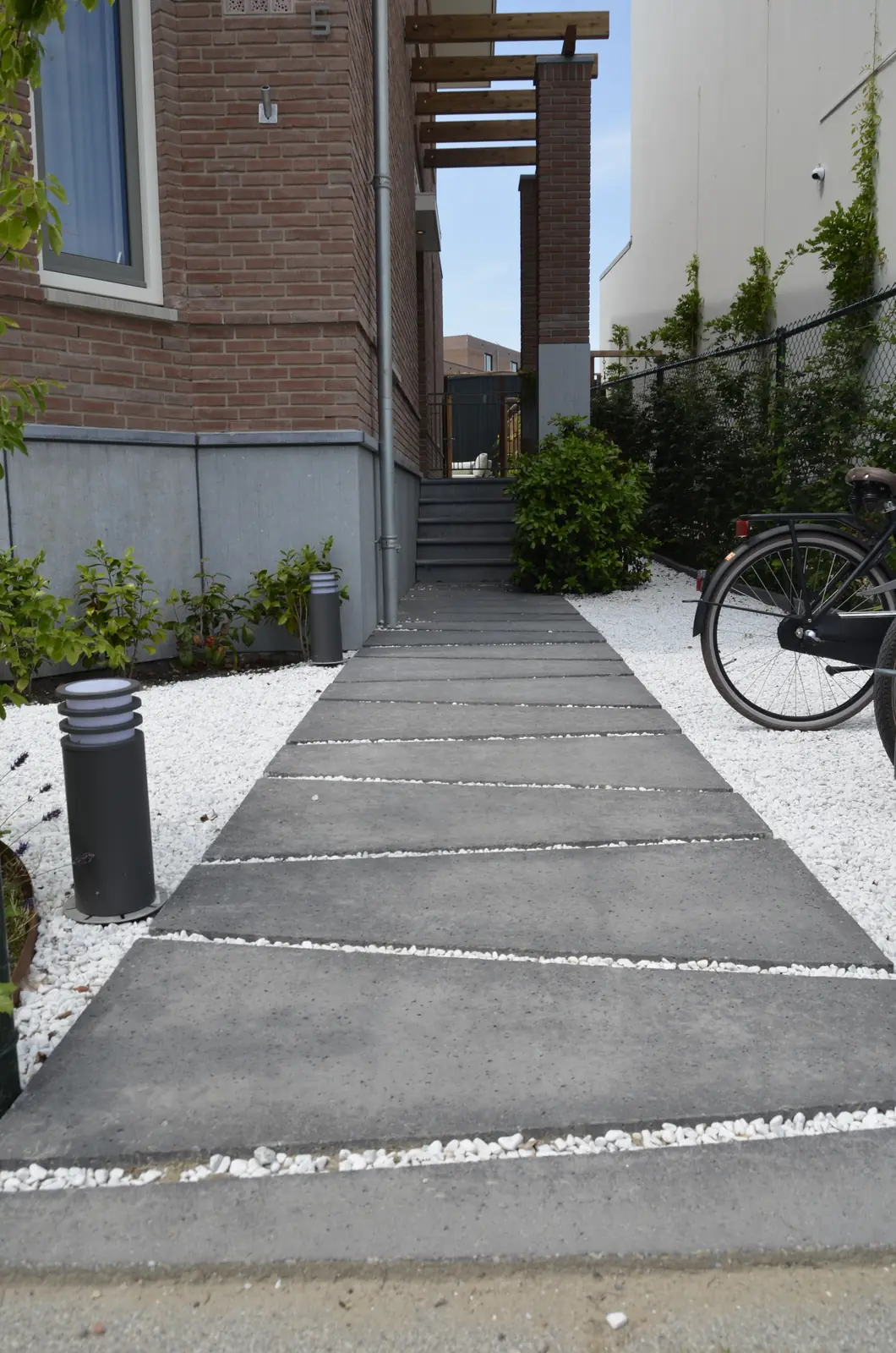 Voorpad met wit grind naast de gevel