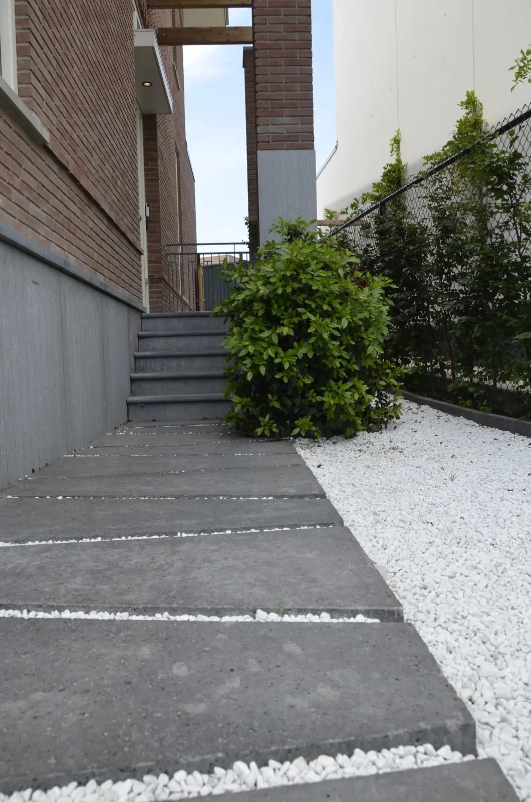 Grindpad langs de gevel met beplanting ernaast